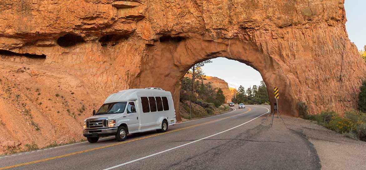 A van drives through a desert canyon