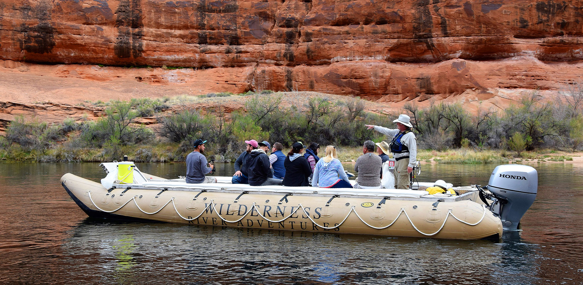 Passengers float down the Colorado River aboard an inflatable raft.