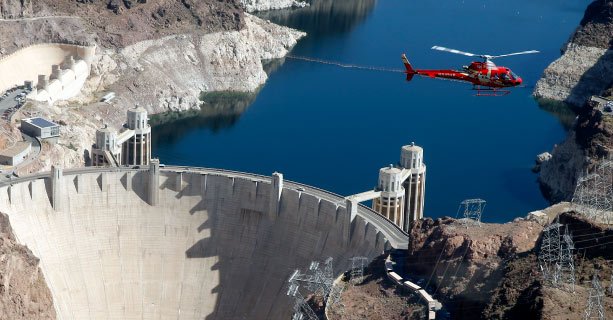 A helicopter in flight above Hoover Dam.
