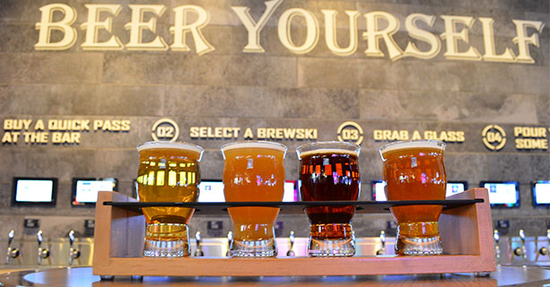 A flight of beers displayed in front of a bar.