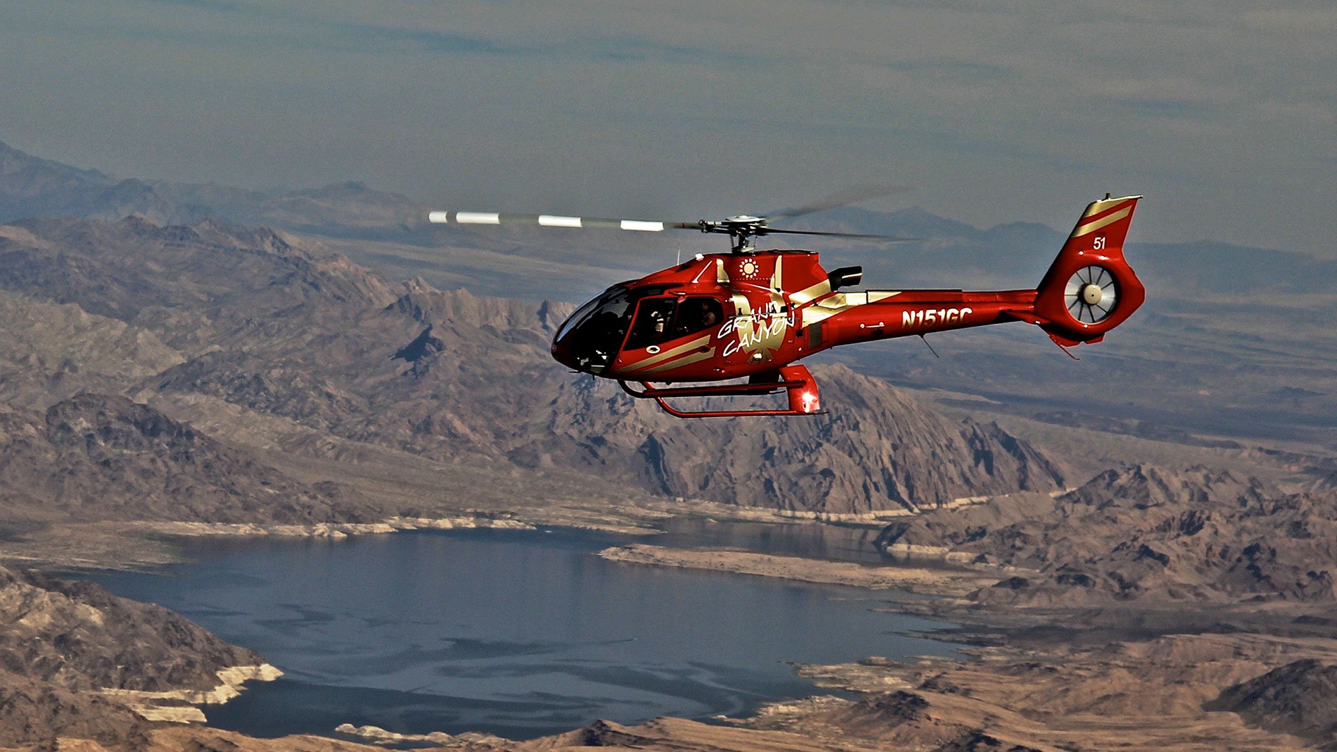 Red EC-130 helicopter flying over Lake Mead