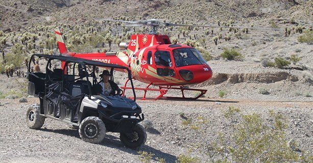 Helicopter landed behind an ATV waiting for passengers.