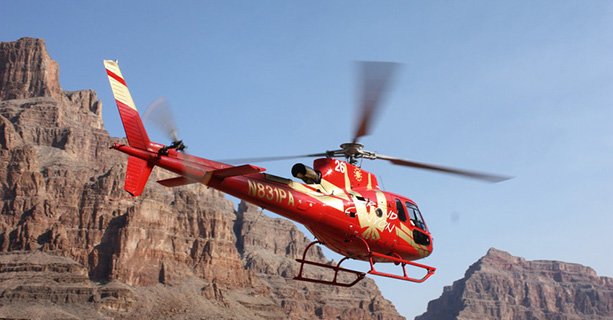 A helicopter cruises between the walls of the Grand Canyon West.