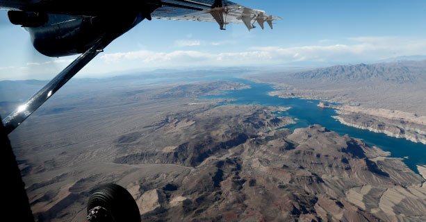 A view of Lake Mead and the surrounding desert from an airplane window.