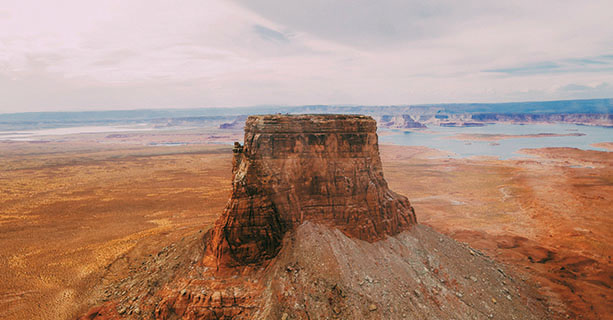 Tower Butte stands in front of a scenic desert landscape.