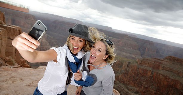 Two women pose for a picture at the edge of the Grand Canyon West.