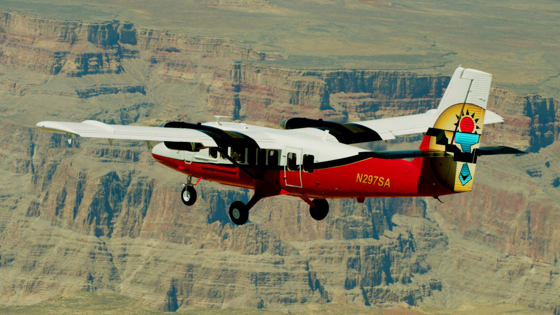 A Twin Otter plane flying over the Grand Canyon West Rim.
