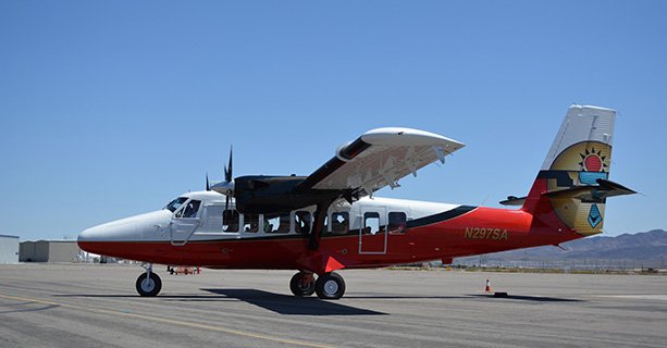 A Twin Otter airplane ready for takeoff at an air terminal.