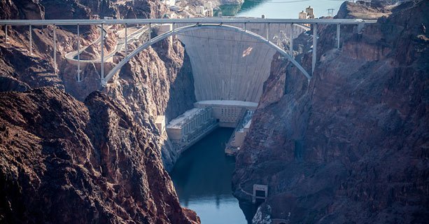 The Hoover Dam with a large bridge in the foreground.