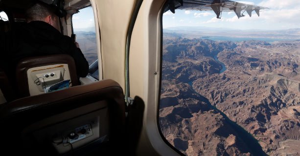 An aerial view of the Colorado River seen from the window of a Grand Canyon airplane tour.