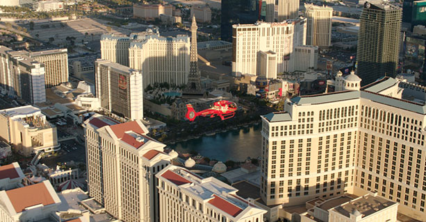 A red helicopter flies over the Las Vegas Strip.