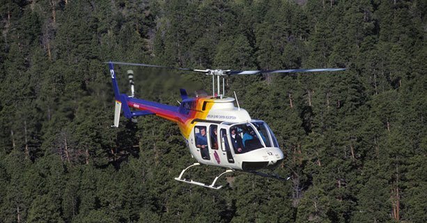 Bell helicopter flying over the Kaibab National Forest en route to the Grand Canyon.