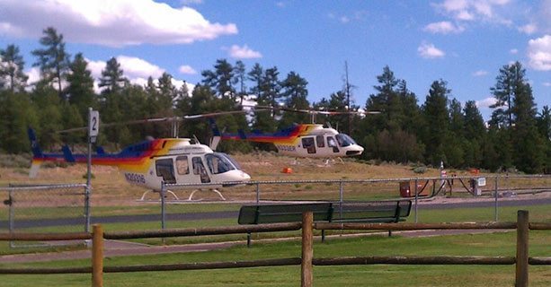 Two Bell helicopters setting off from the Grand Canyon National Park heliport.