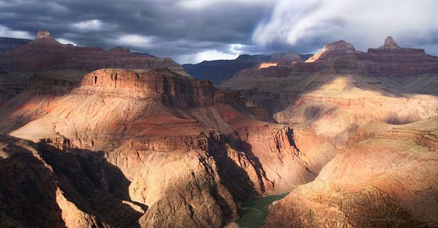 The Grand Canyon lit by partly cloudy skies.