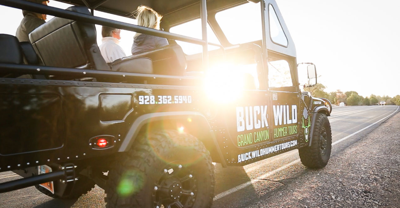 A touring Hummer vehicle with the sun beaming through the windows.