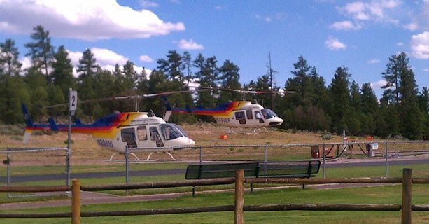 Two Bell helicopters landing at the Grand Canyon National Park heliport.