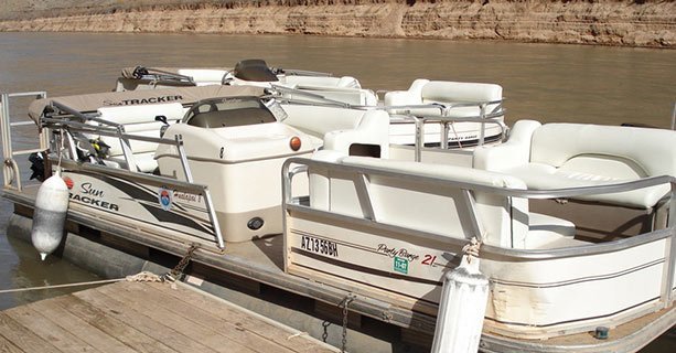 A touring pontoon boat docked along the Colorado River.