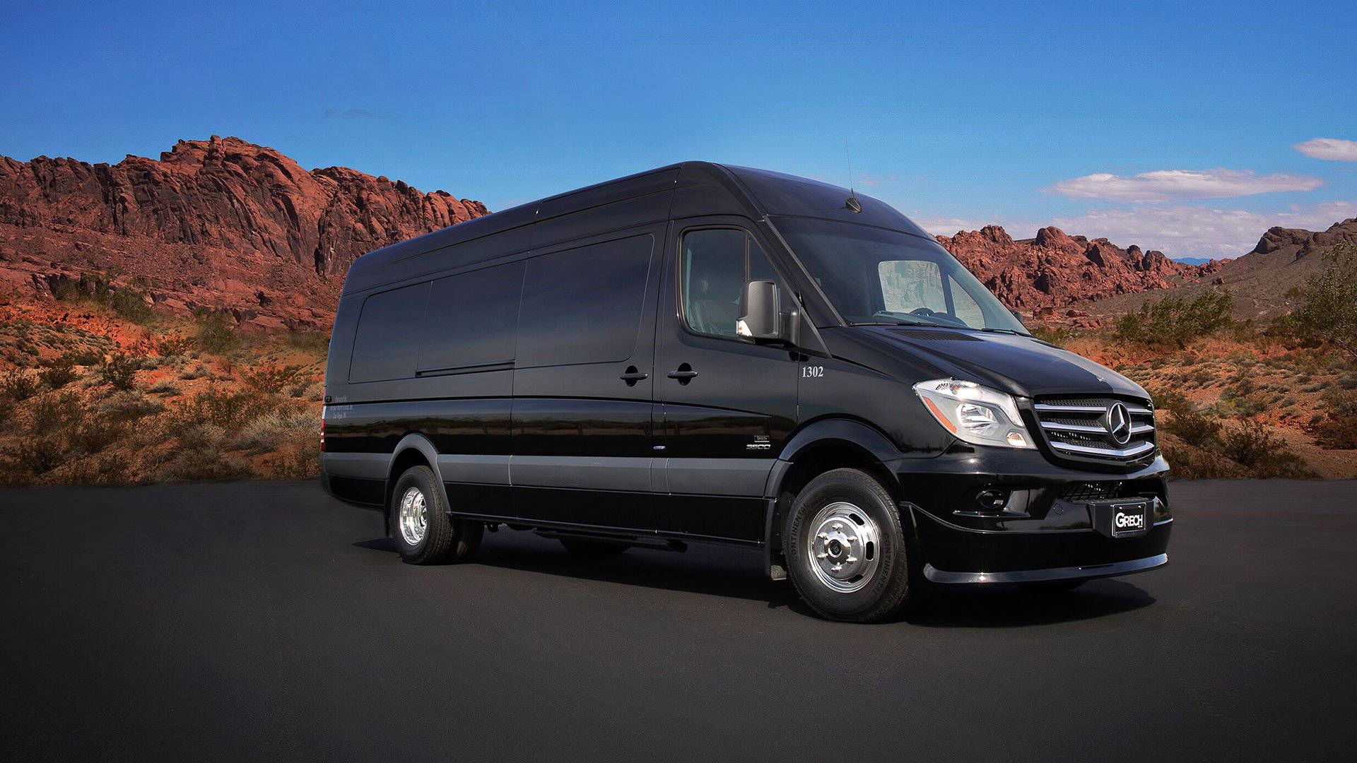 A black Sprinter vehicle parked in front of desert scenery.