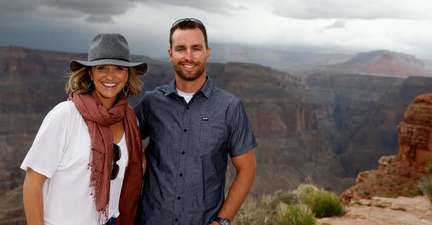 A couple poses together at the edge of the Grand Canyon West.