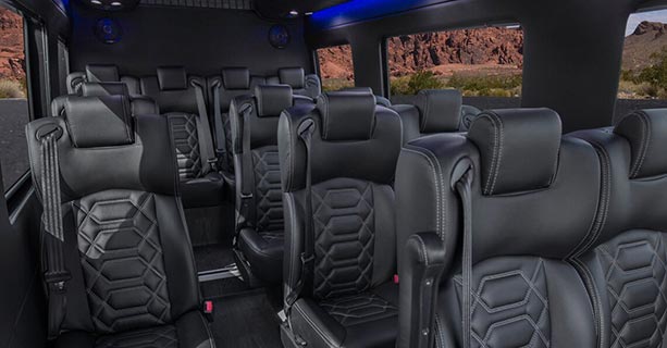 Interior view of a Sprinter touring vehicle's black leather seats.