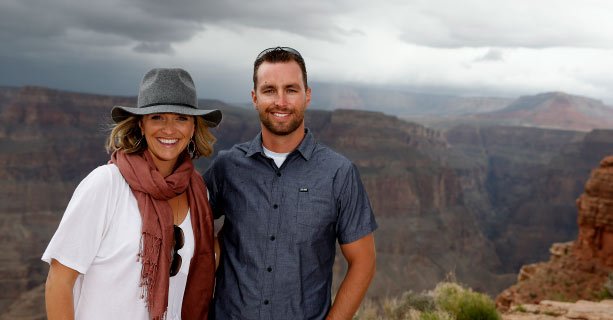 A couple poses together in front of the Grand Canyon.