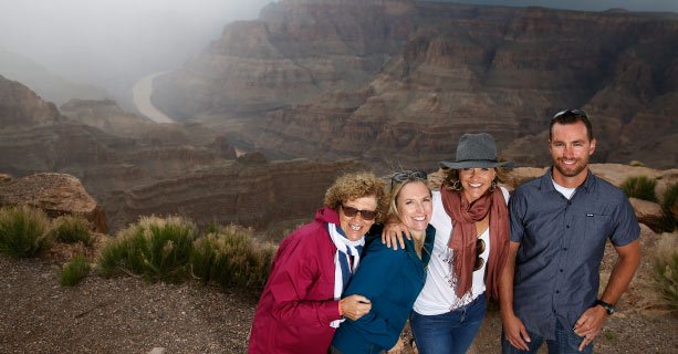 A family poses together at the edge of the Grand Canyon West.