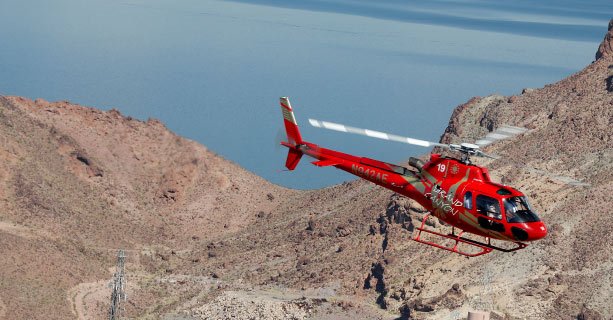 Bell helicopter soaring over the desert landscape and Lake Mead.