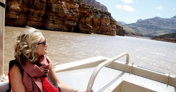 A woman sightseeing aboard a pontoon boat travelling down the Colorado River.