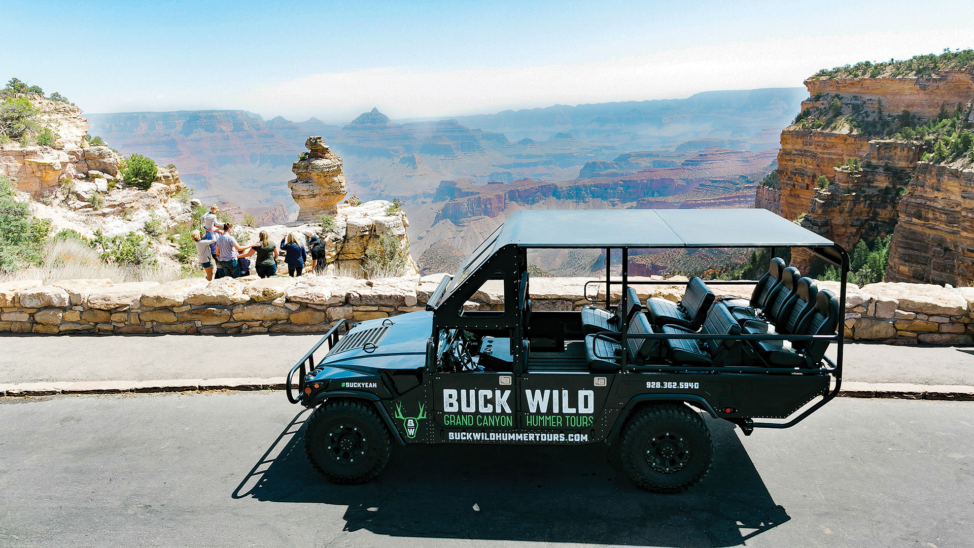 A Hummer vehicle parked while passengers sightsee at the Grand Canyon.