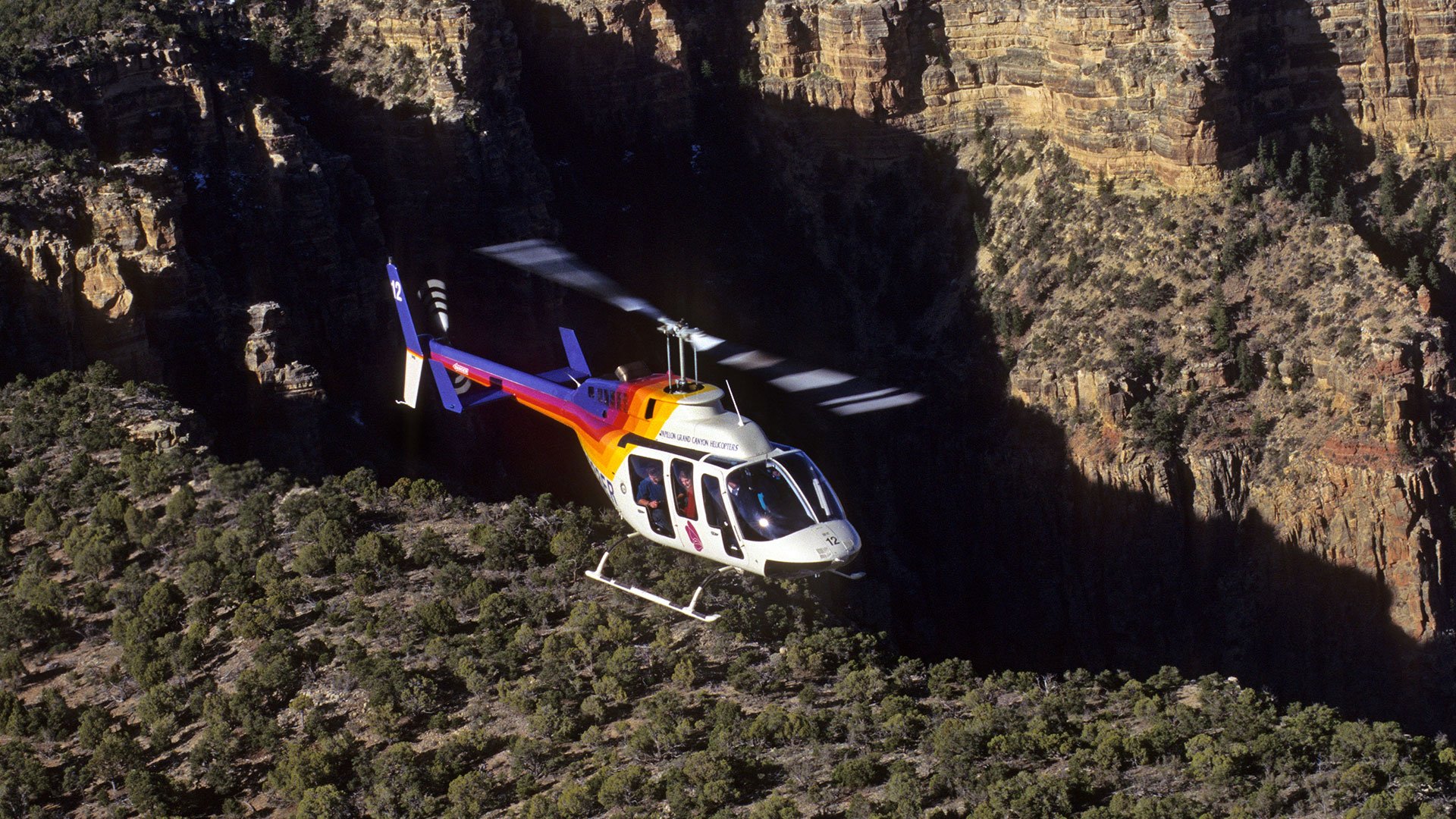 Bell helicopter flying over the Grand Canyon South Rim.