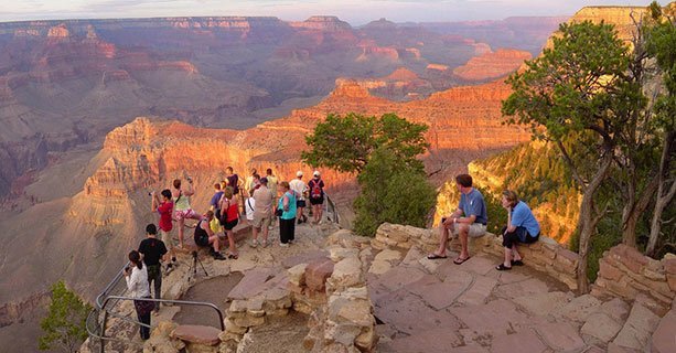 Sightseers stand at the edge of a Grand Canyon viewpoint.