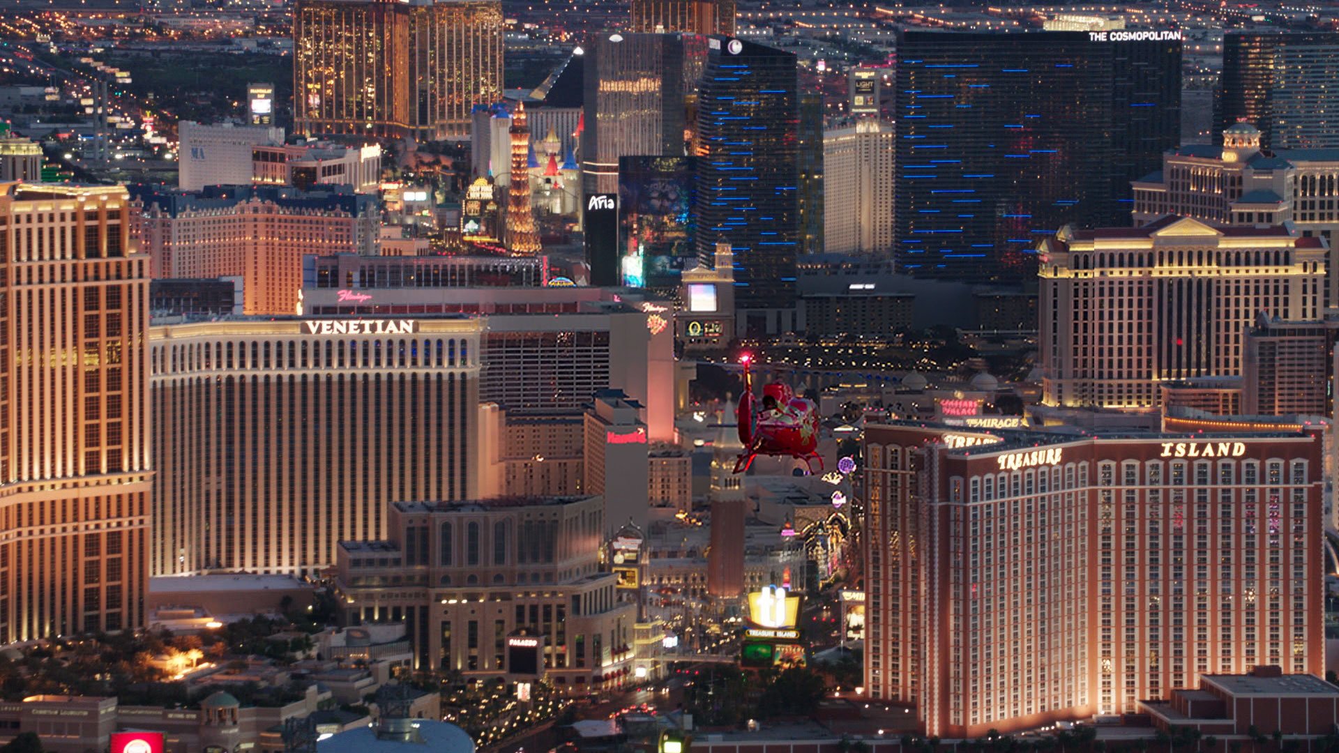 An EC-130 helicopter flies over the Las Vegas Strip at night.