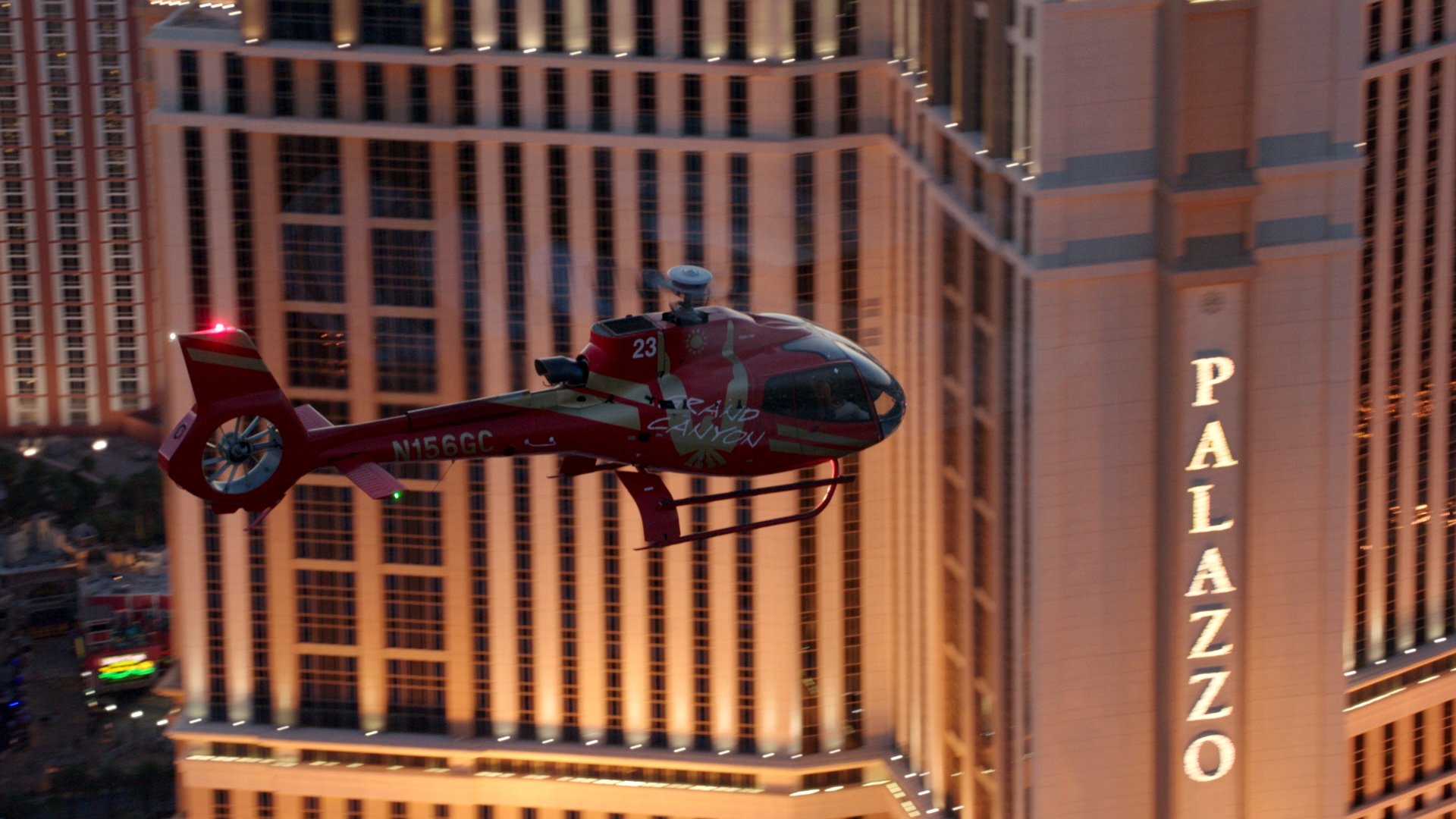 An EC-130 helicopter flying over the Las Vegas Strip with the Palazzo hotel in the background.