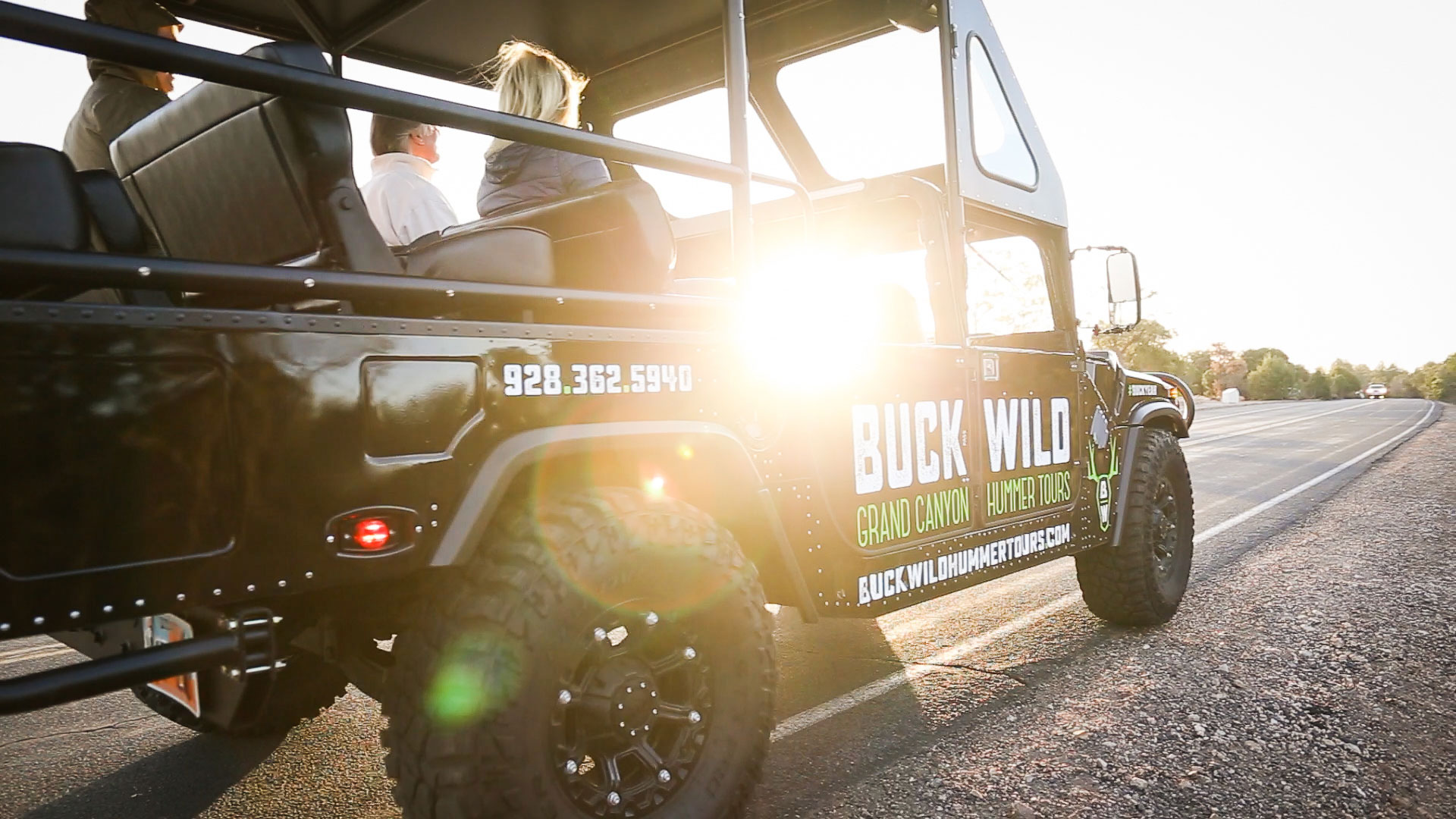 A touring Hummer with the sunset beaming through the windows.