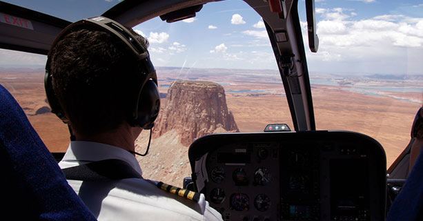 A helicopter pilot navigates toward the top of Tower Butte.