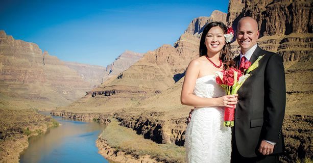 A bride and groom standing together on the canyon floor.