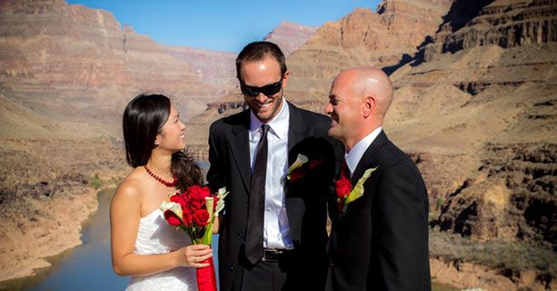 Newlyweds share a laugh with their minister at the bottom of the Grand Canyon.