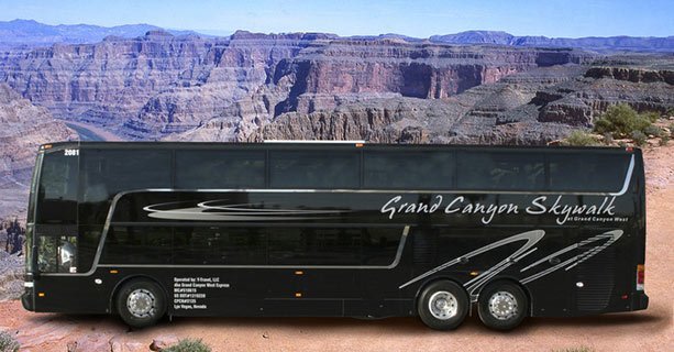 A black motorcoach parked with Grand Canyon scenery in the background.