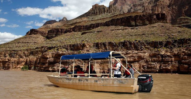 A pontoon boat cruises down the Colorado River.