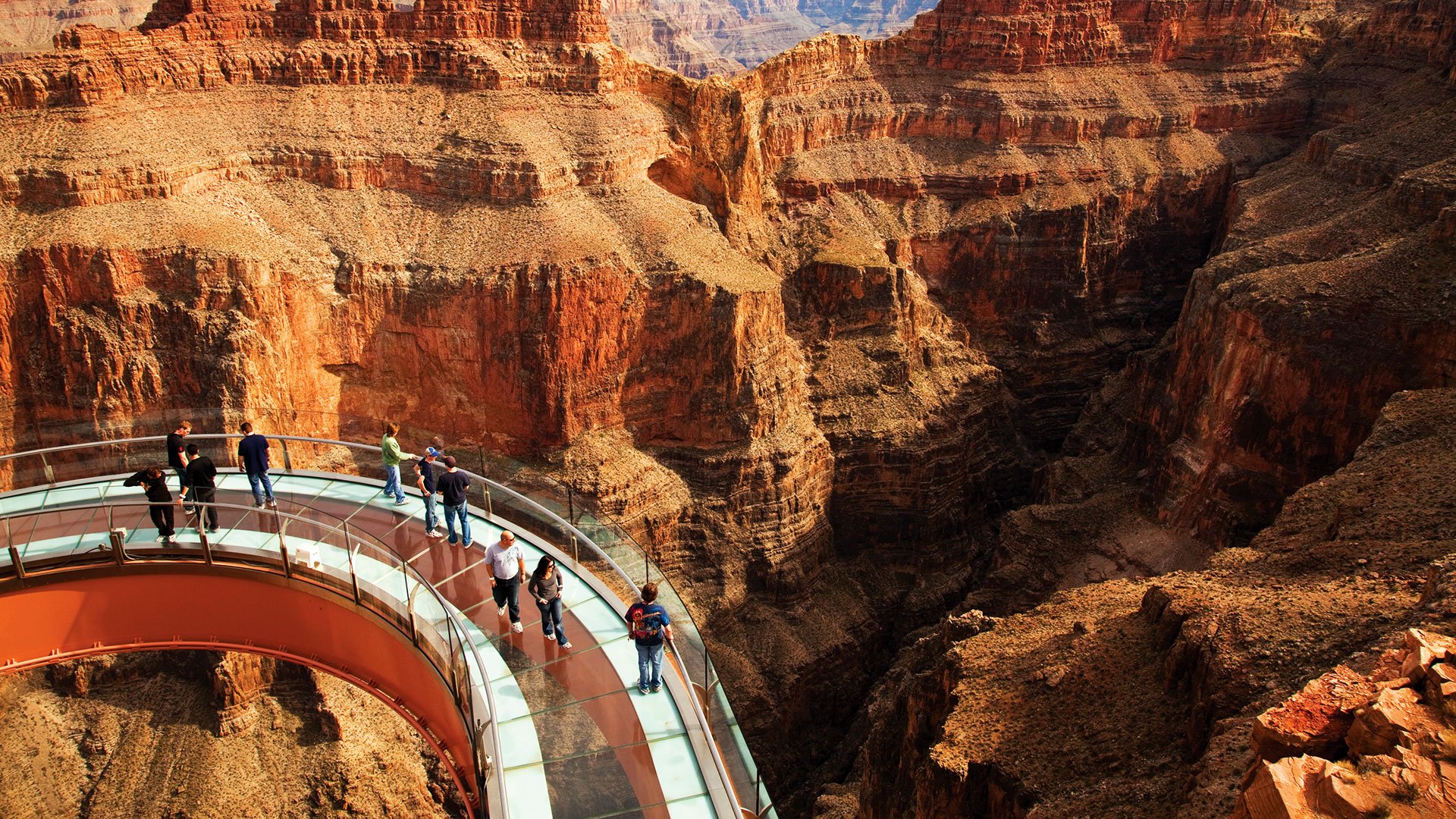 Guests walking on the Skywalk glass bridge with the Grand Canyon in the background.