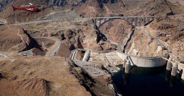 A helicopter flies above the Hoover Dam.